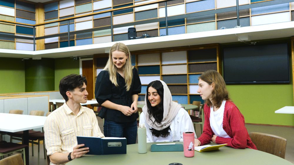 studenter rundt et bord i samtale