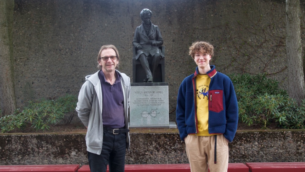 Utdanningsleder og student foran statue av Nils Henrik Abel