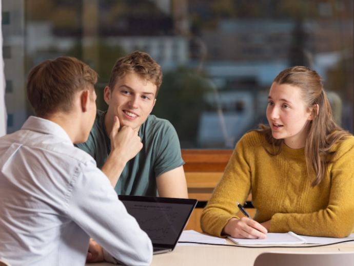 Tre studenter som diskuterer