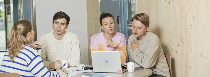 Fire lærere sitter rundt et bord og diskuterer