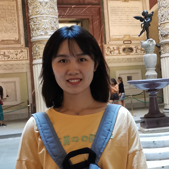 A photo of a girl with dark short hair, wearing a yellow T-shirt and blue backpack. 