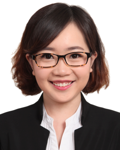 A portrait of a woman with brown eyes and short brown hair, wearing glasses and suit. 