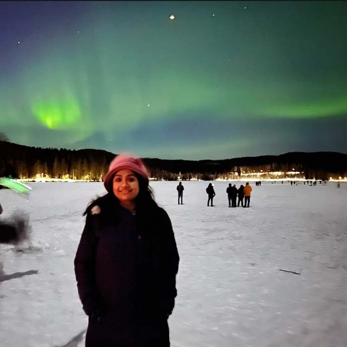 Young Indian woman in front of Northern lights at Sognsvann